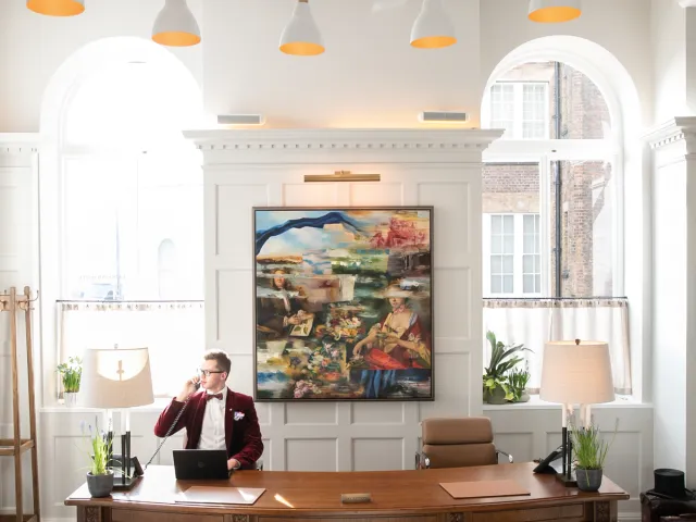 Receptionist speaking on the phone at a front desk to represent contact and customer service.