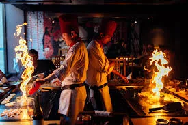Benihana chefs preparing teppanyaki dinner at tabletop hibachi grills