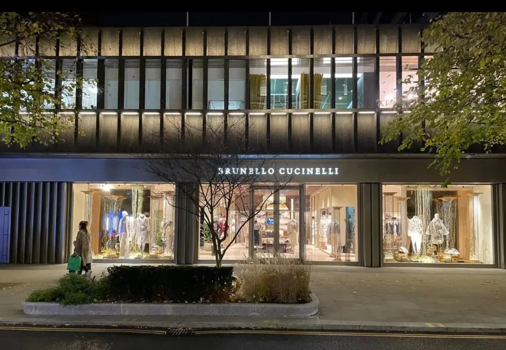 Brunello Cucinelli boutique storefront on a Chelsea street at night