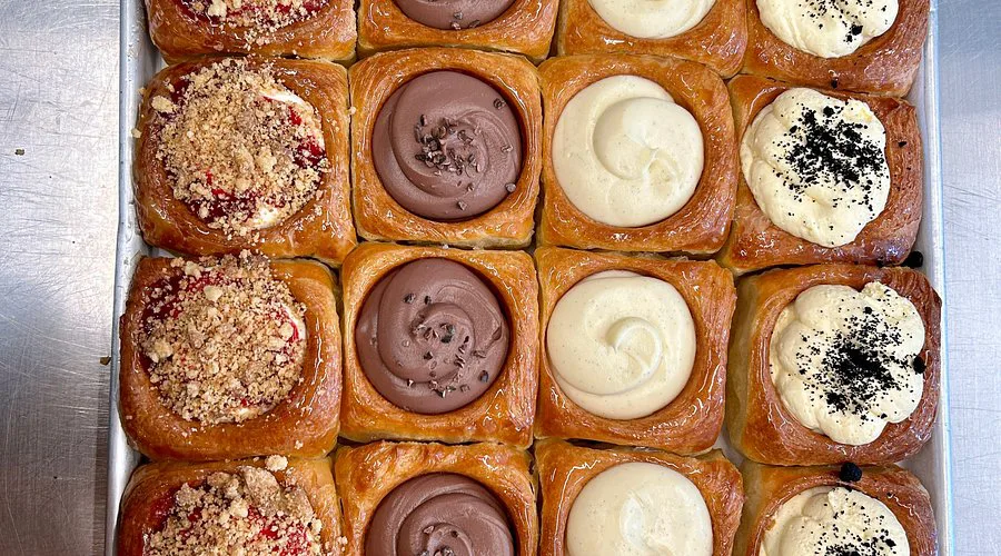 Assorted filled pastry buns on a baking tray