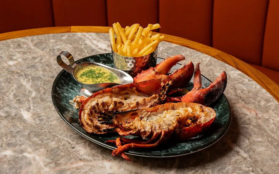Grilled lobster halves with fries and herb butter sauce