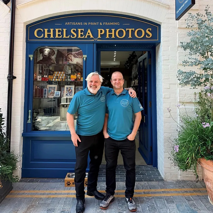Two men posing at the entrance of Chelsea Photos as shop staff.