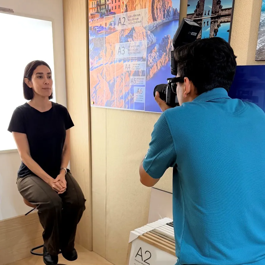 Portrait session of a seated woman having headshots taken by a photographer.