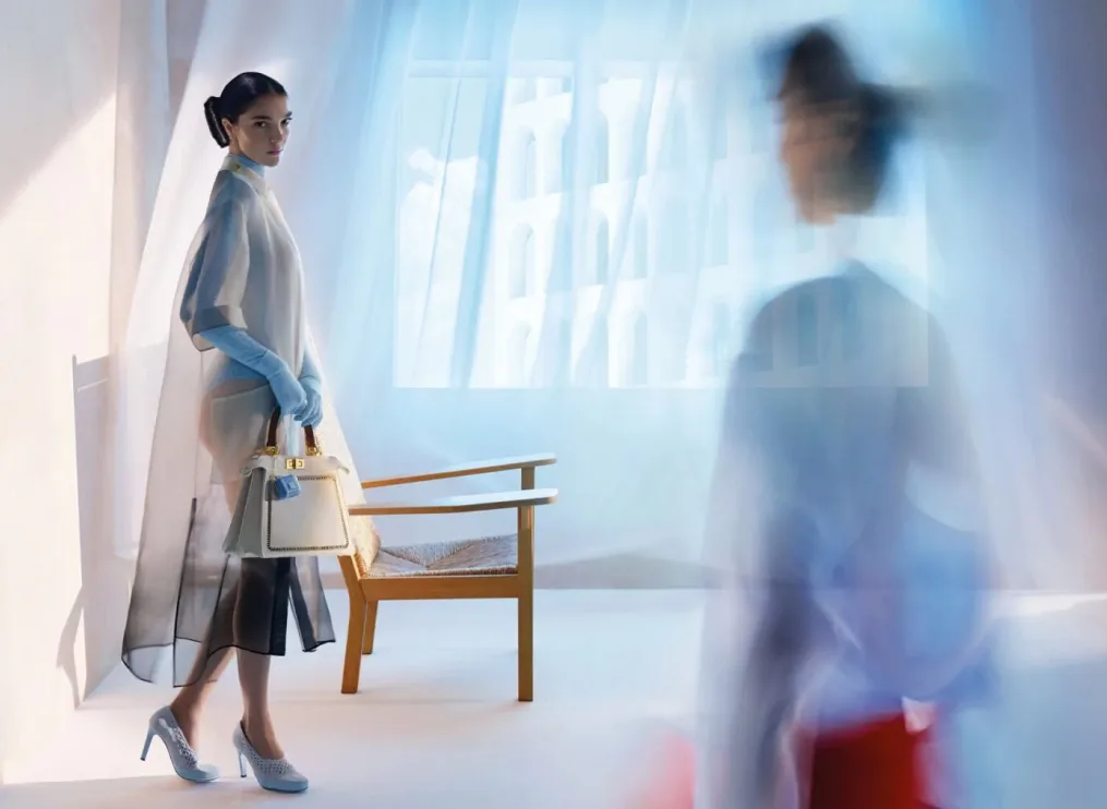 Model showcasing a luxury Fendi handbag in a dreamy editorial fashion scene