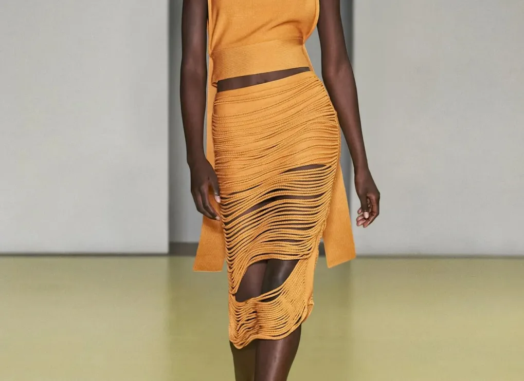 Model showcasing Ferragamo knit ensemble with deconstructed cutout skirt and matching top