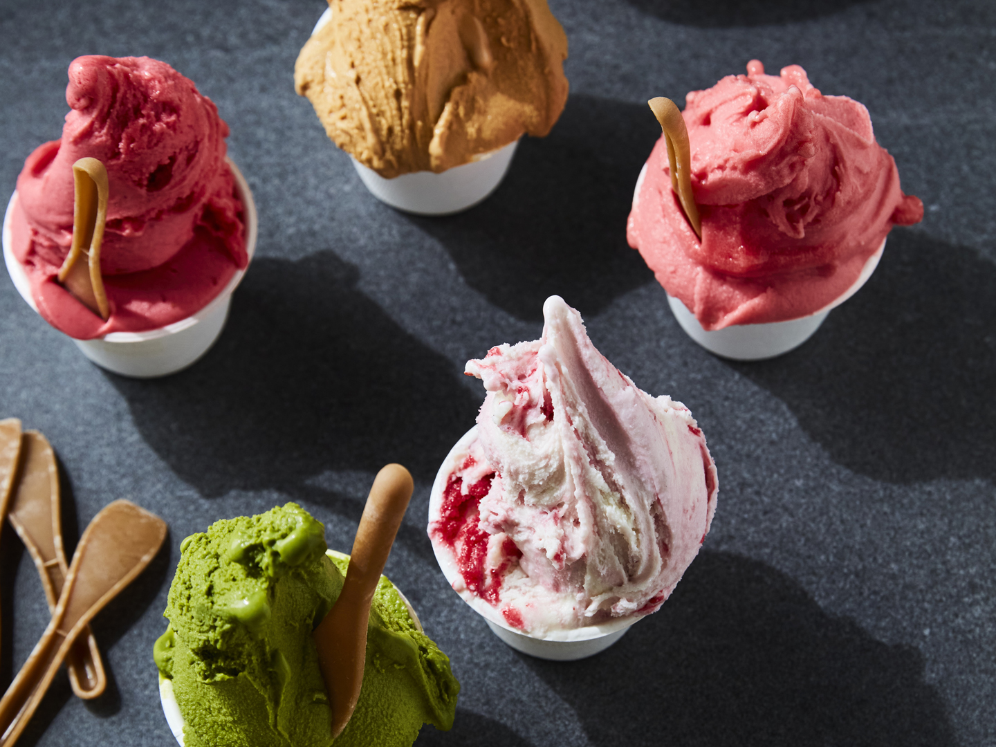 Ice cream scoops in paper cups suggesting menu flavors and offerings.