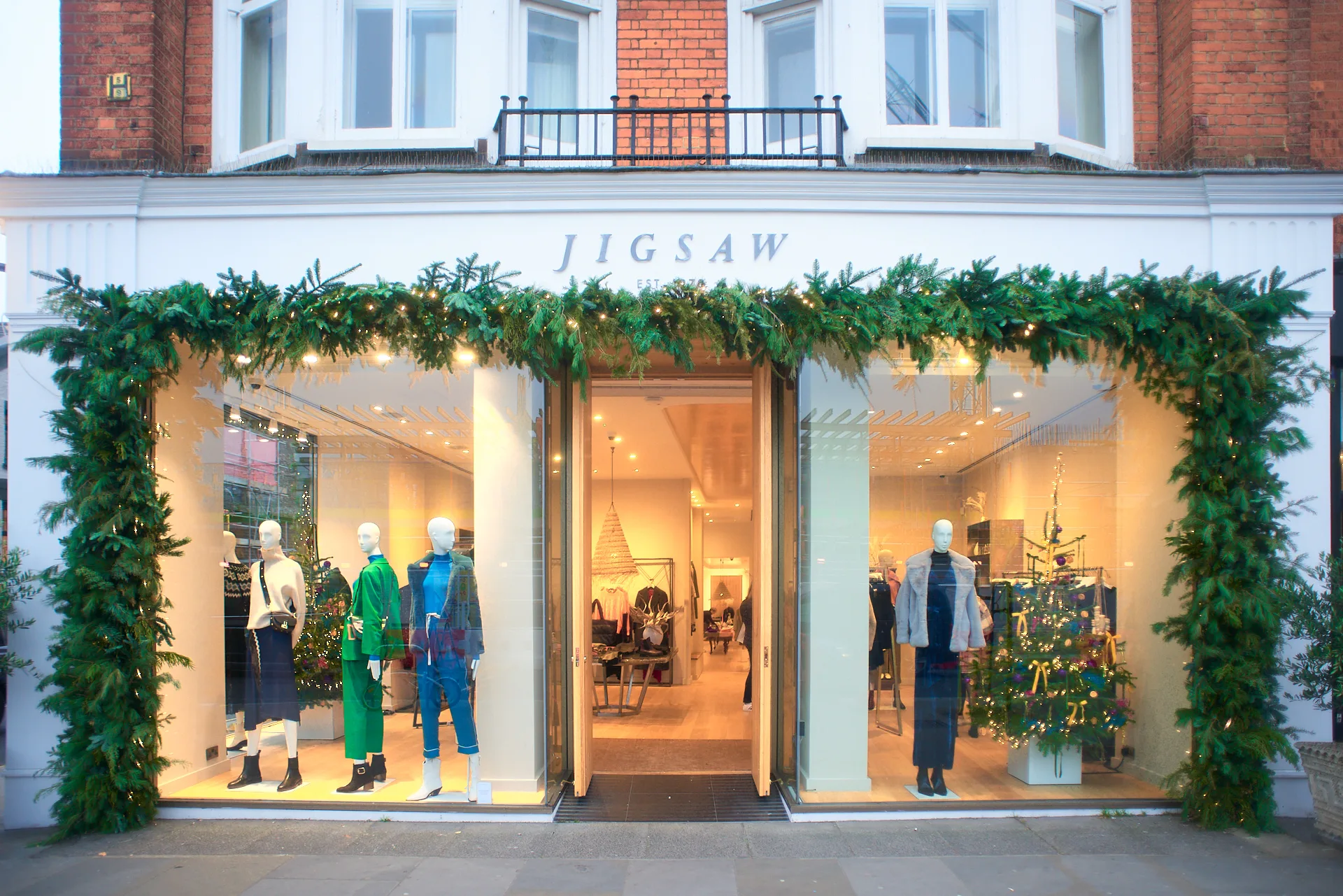 Jigsaw clothing store storefront with holiday window display showcasing seasonal apparel