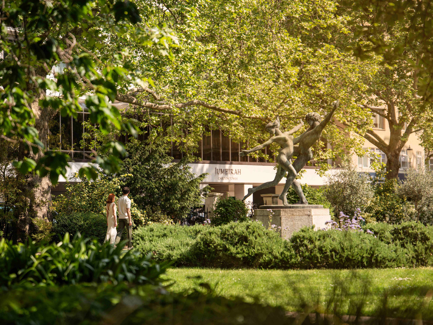Jumeirah Carlton Tower entrance with bronze dancing sculpture and landscaped garden