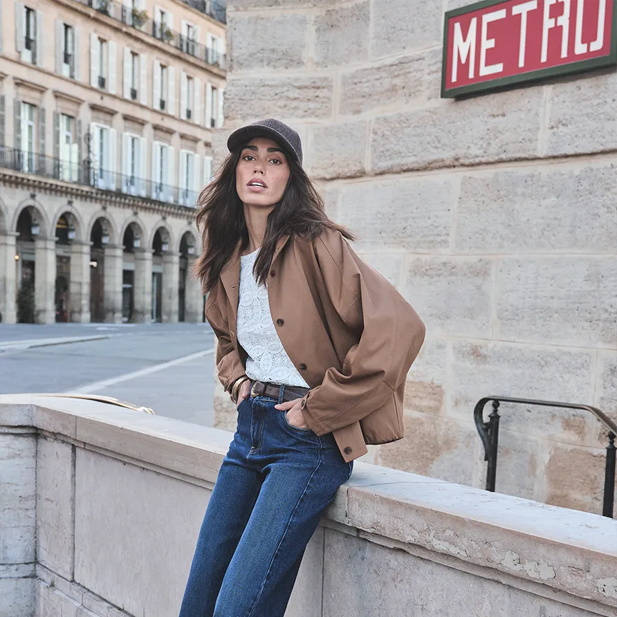 Model wearing a casual jacket with a lace top and high-waist jeans for a Maison 123 lookbook.