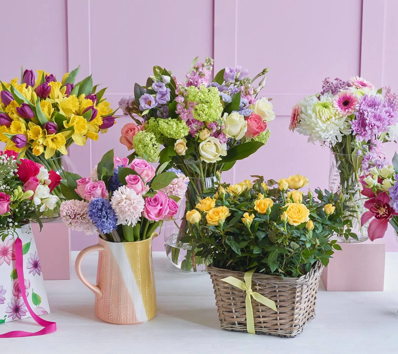 Assorted floral gift arrangements in vases and a wicker basket