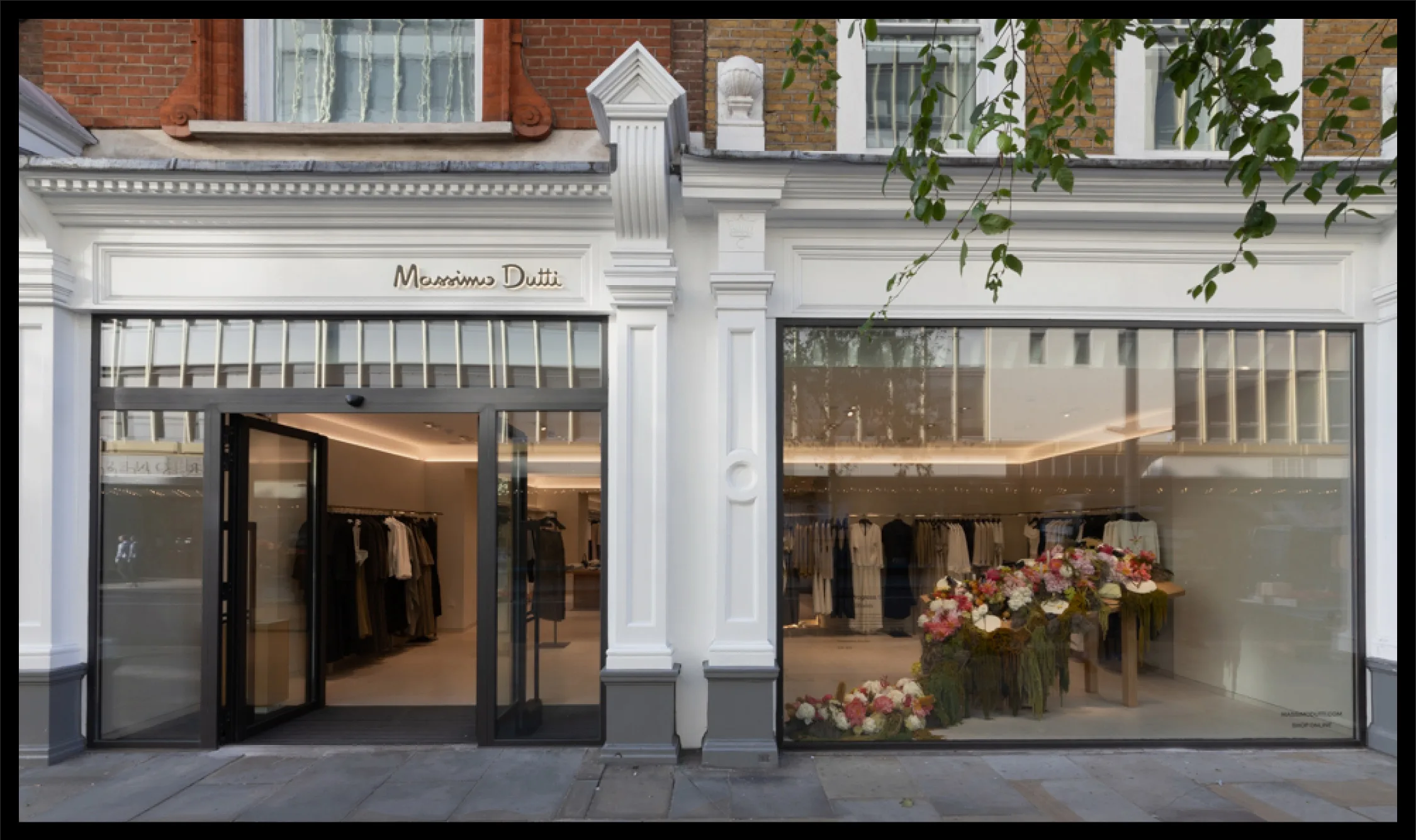 Massimo Dutti storefront with boutique entrance and floral window display