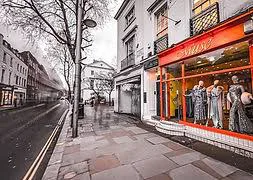 Boutique storefront with window mannequins on a Chelsea sidewalk