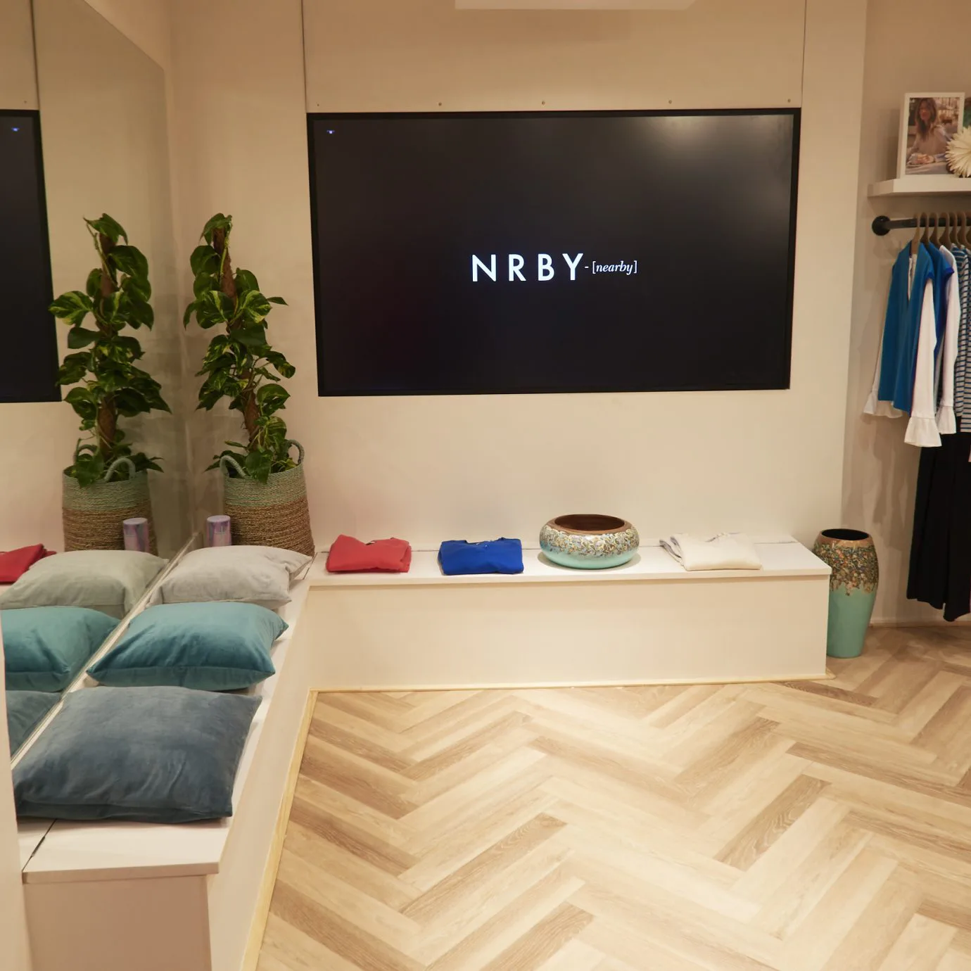 NRBY retail fitting room with bench seating and prominent brand logo