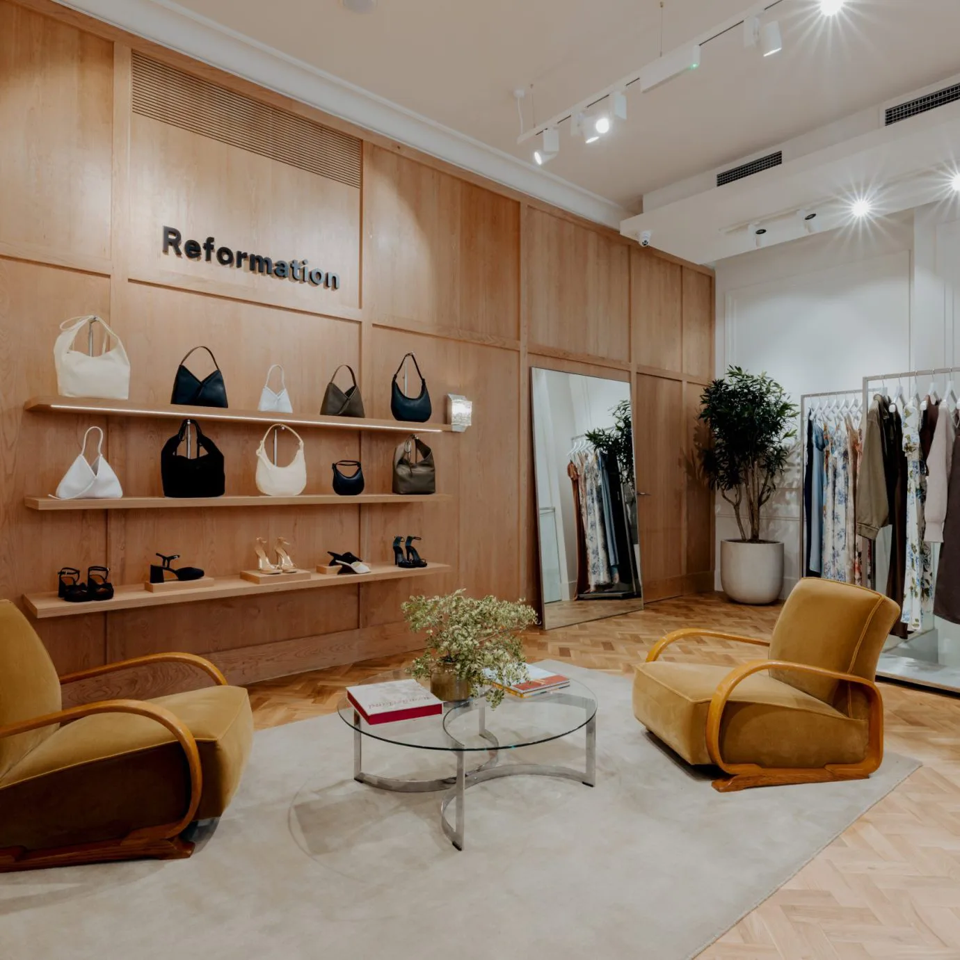 Reformation boutique interior with a seating area for trying on and browsing women's clothing and accessories.