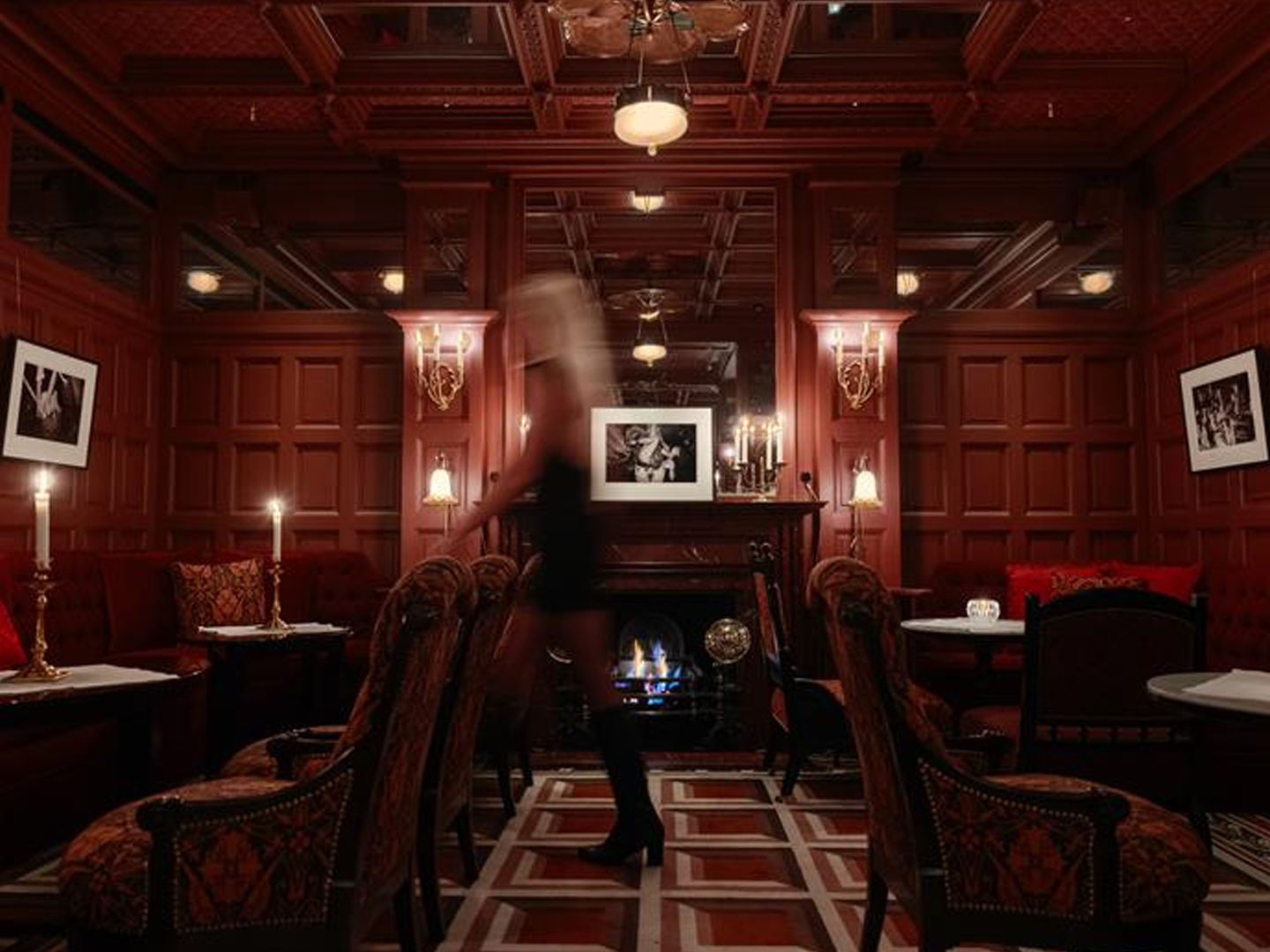 Upscale lounge bar with a fireplace and a blurred server walking through