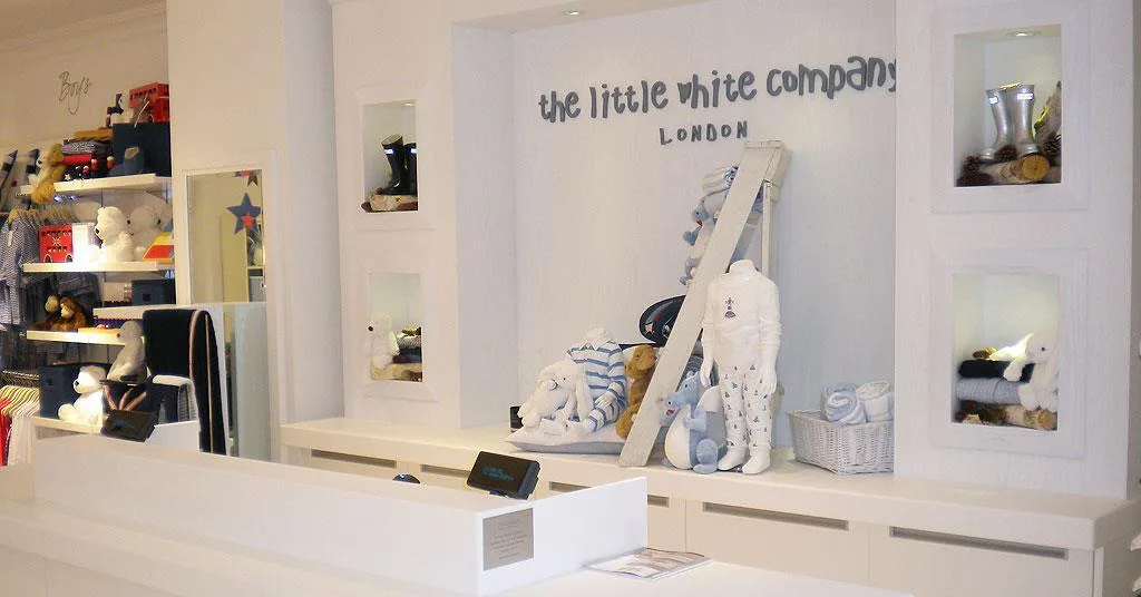 The Little White Company London store interior with a retail display for children's and nursery items.