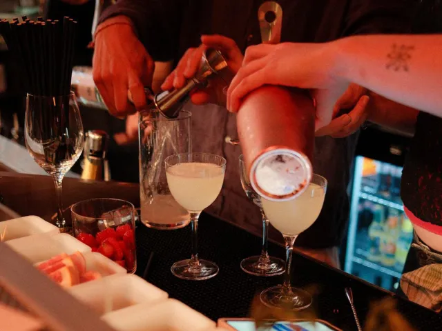 Bartenders pouring cocktails at a bar