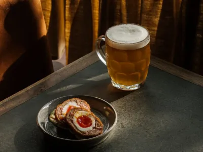 Pint of beer and a Scotch egg on a small plate as a pub snack