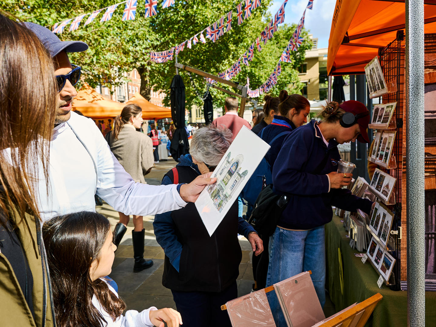 Visitors browsing artwork and prints at an outdoor Chelsea Art Market