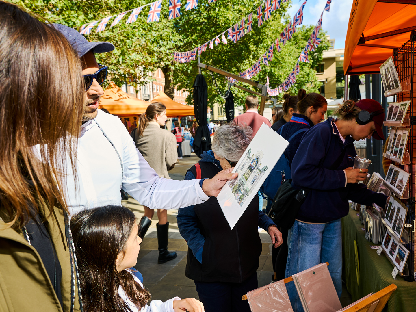 Shoppers browsing prints at an outdoor Chelsea art market