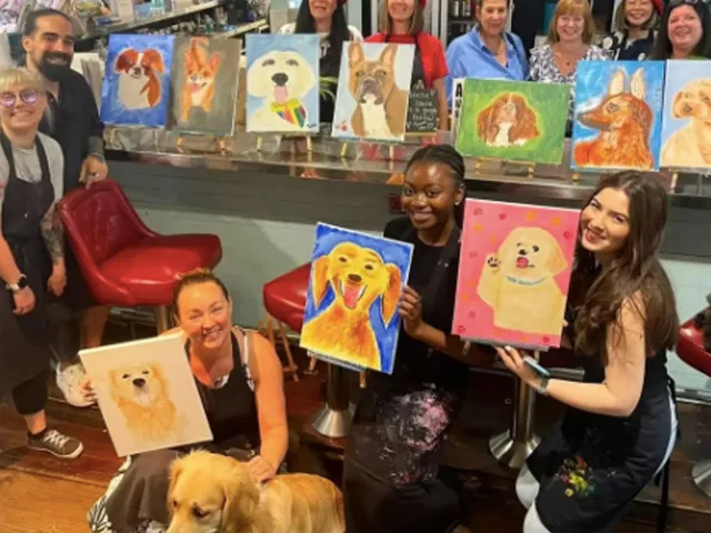 Participants at a Chelsea Dog Day paint-and-sip creating dog portrait paintings.