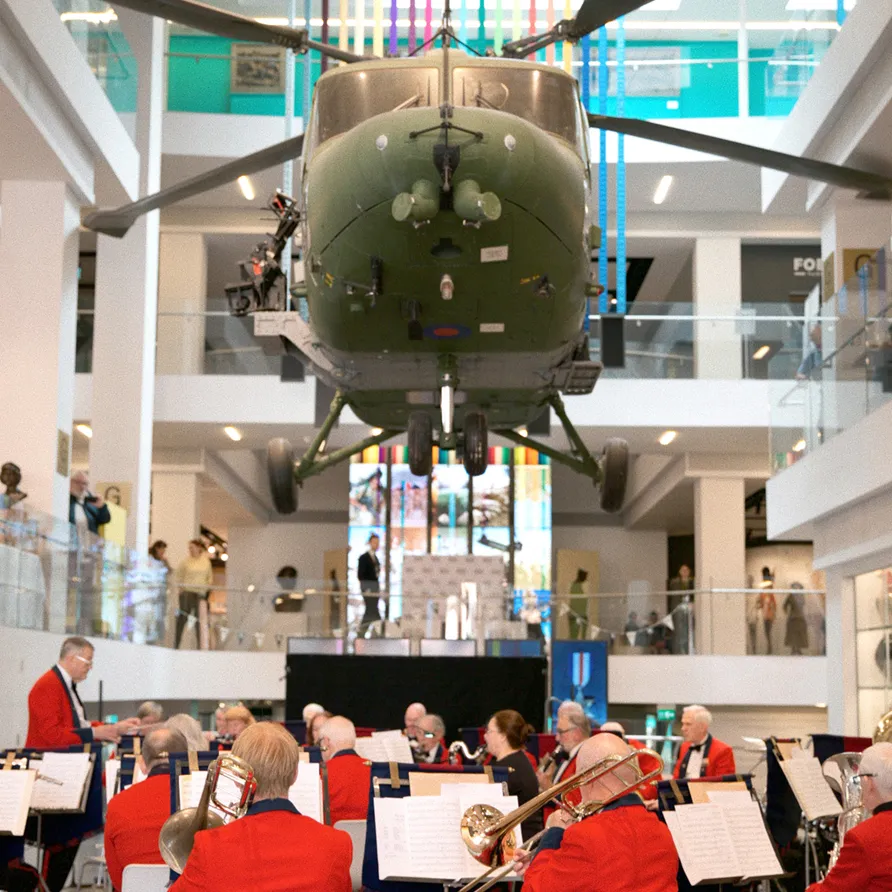 Helicopter suspended above a band performing in a museum atrium at the Chelsea History Festival.