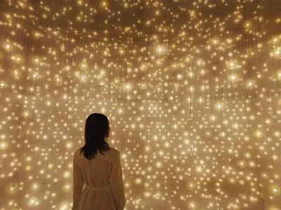 Visitor experiencing an immersive light installation that evokes a starry sky.