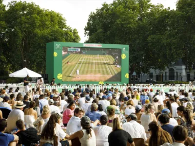 Outdoor public screening of a tennis match for a large seated audience