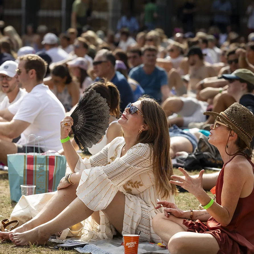 Audience relaxing on the grass at an outdoor summer film screening