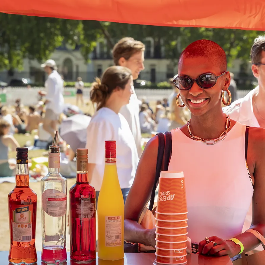 Smiling vendor serving drinks at an outdoor festival