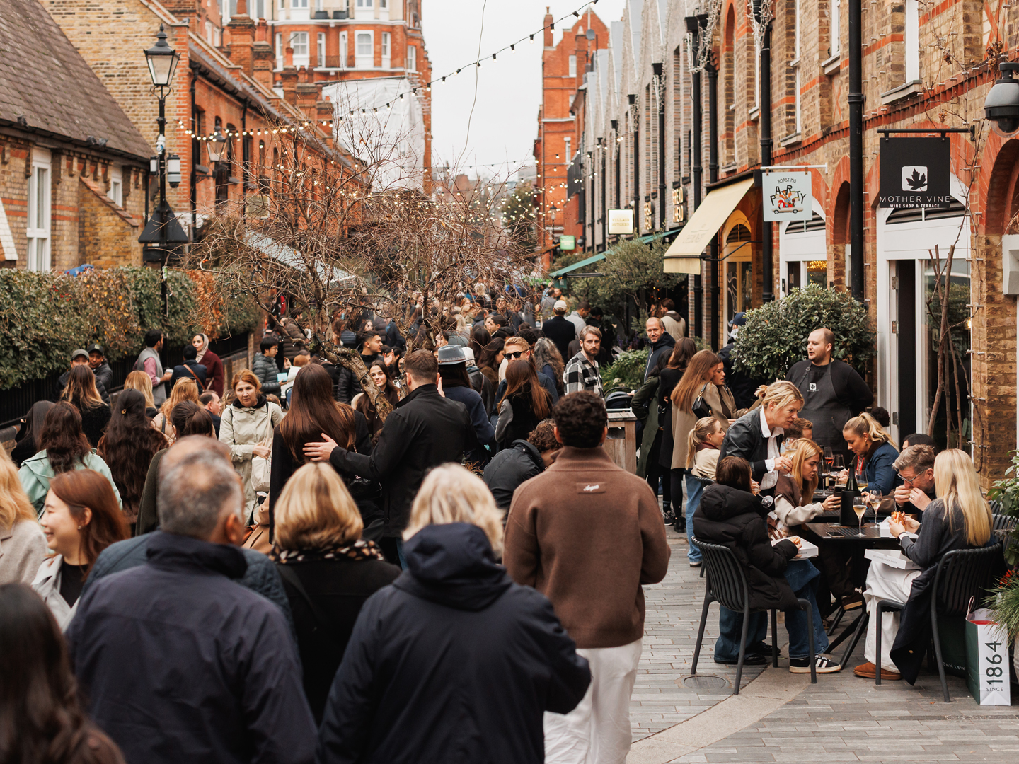 Crowded Chelsea pedestrian street with families enjoying outdoor dining and shopping