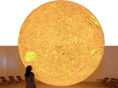 Giant illuminated sun installation in a gallery inviting visitors to view and reflect