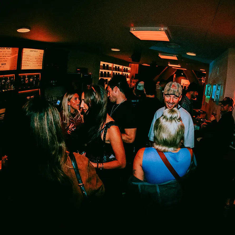 Crowd socializing and laughing inside a busy bar on King's Road.