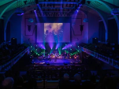 Live concert in a historic theater with a band onstage and an audience