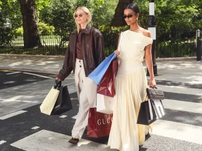 Two fashionable women carrying luxury shopping bags on Sloane Street