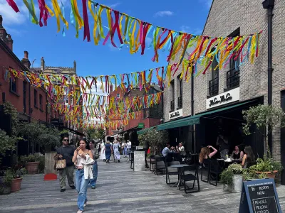 Lively Chelsea pedestrian street with outdoor cafés, diners and shoppers beneath festive bunting