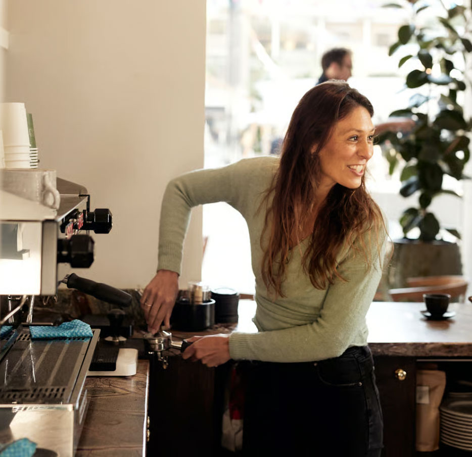 Barista preparing espresso behind the counter at a Chelsea café.
