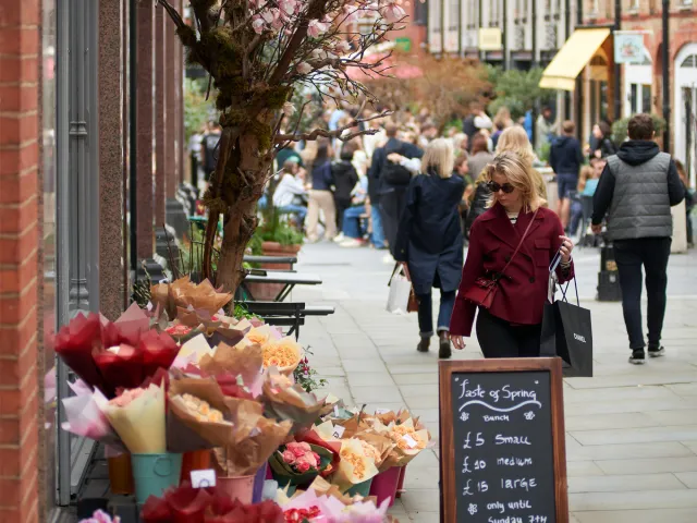 Busy Chelsea shopping street with flower stalls and shoppers